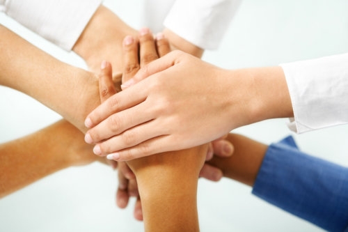 multi colored hand of people hand in unity to express togetherness in community