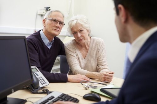 senior couple meeting with consultant in hospital